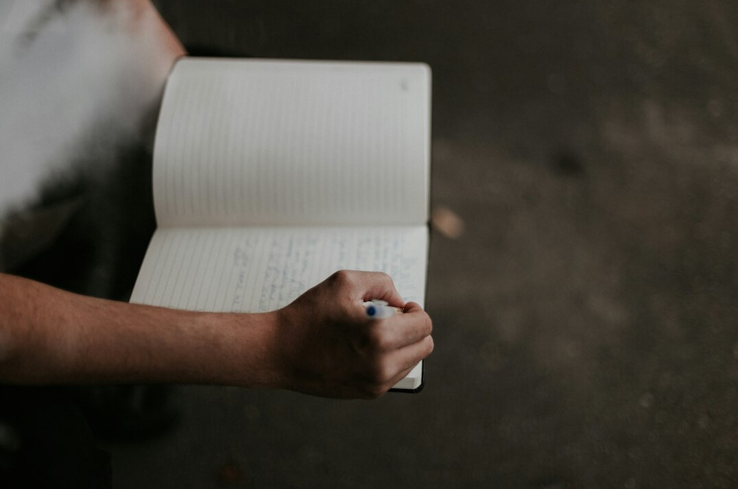person writing goals in notebook